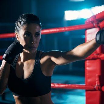 Mujer boxeando en rin rojo