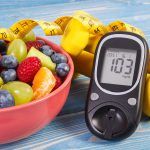 Ensalada de frutas, medidor de glucosa, centímetro y pesas