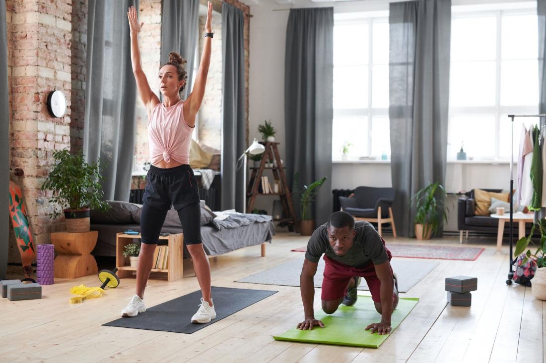 hombre y mujer haciendo ejercicio en casa