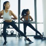 Dos mujeres jóvenes haciendo ejercicio aeróbico en el gimnasio