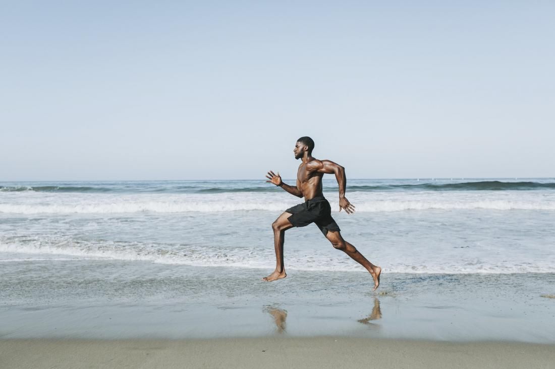 Entrenamiento fisico. hombre corriendo en la playa Entrenamiento fisico. hombre corriendo en la playa