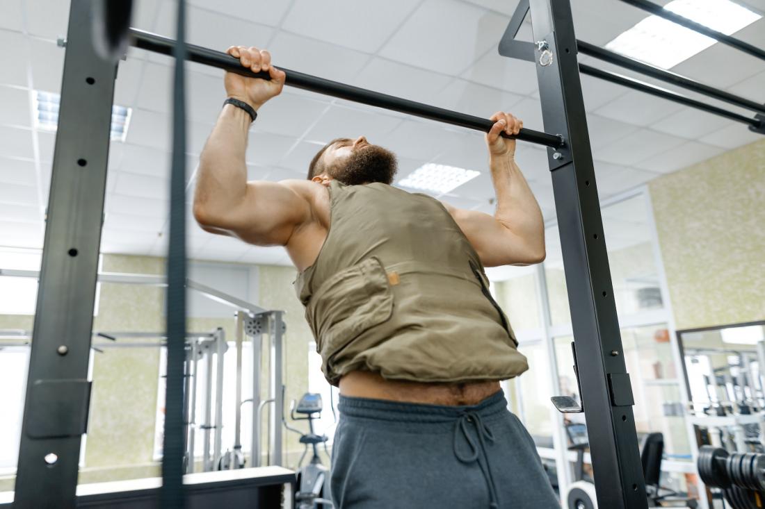 Deporte militar, hombre adulto barbudo caucásico musculoso haciendo ejercicios en el gimnasio