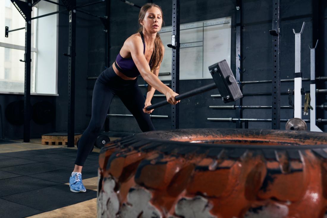 Mujer haciendo CrossFit con mazo