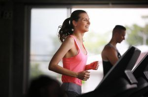 Female exercising with personal trainer at gym