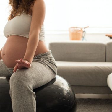 Mujer embarazada haciendo ejercicios de relajación con fitball