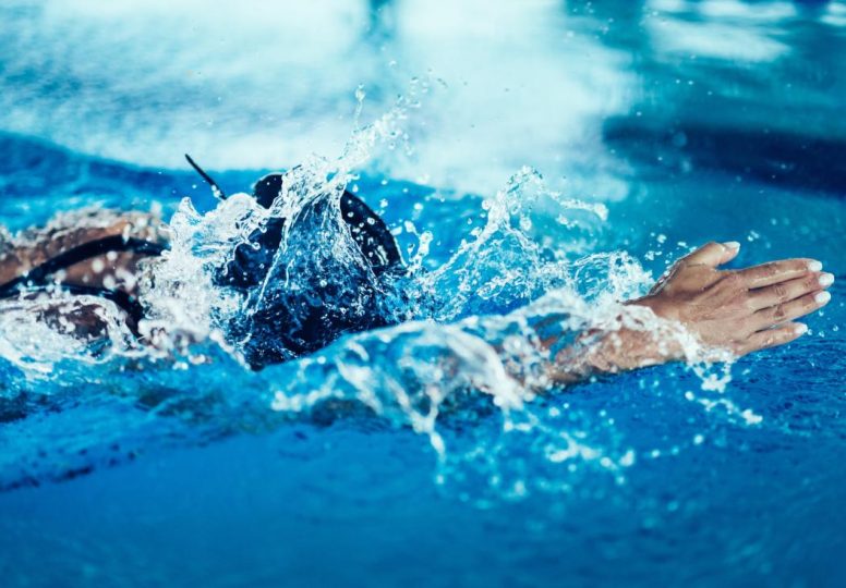 Nadador profesional en entrenamiento, piscina cubierta.