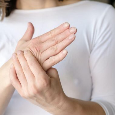 La mujer masajea la palma dolorida